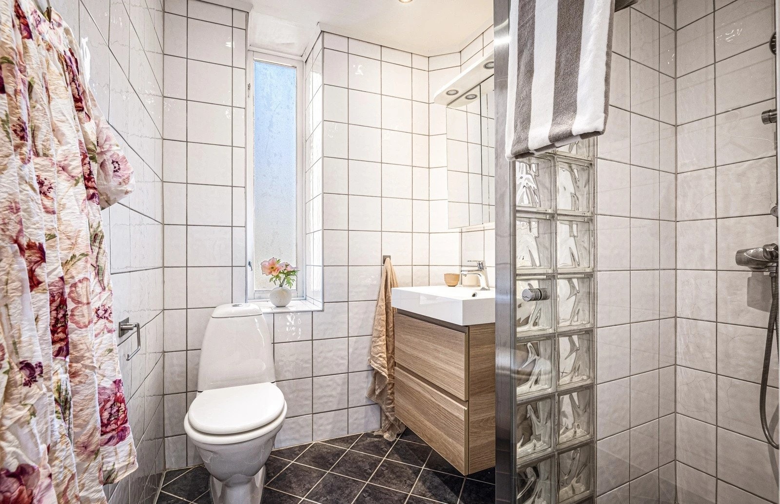 Badet inneholder toalett, dusj og servant Galleribilde