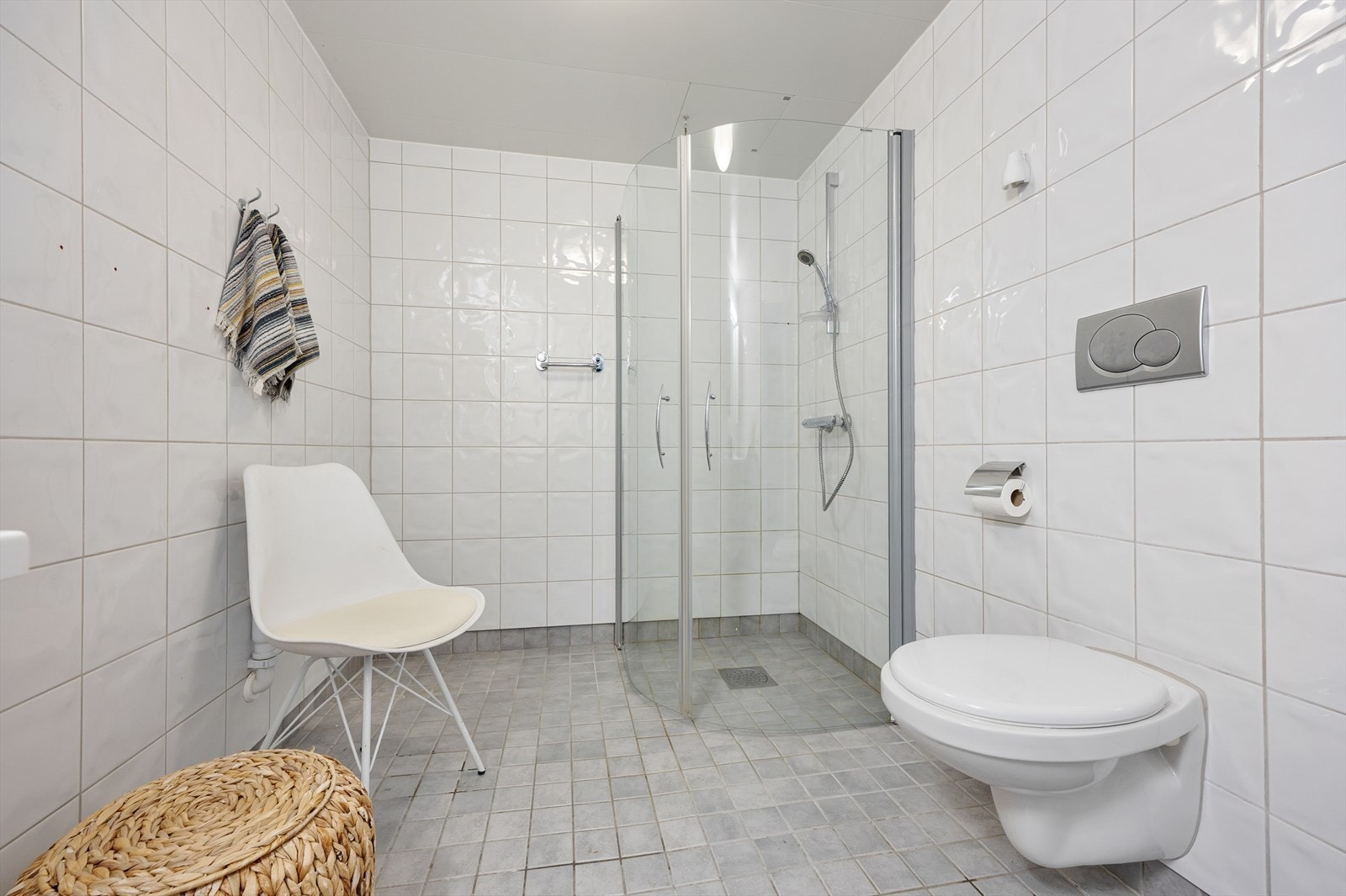 Badet er innredet med vegghengt toalett, servant i baderomsinnredning og dusjhjørne. Galleribilde