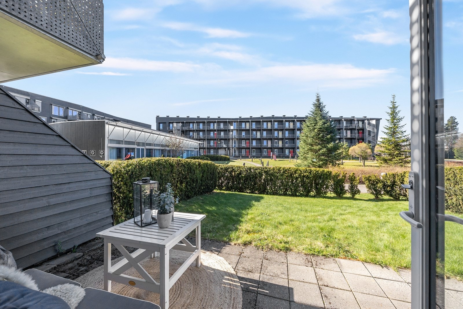 Terrasseplatting og hageflekk med hekk for skjerming. Galleribilde