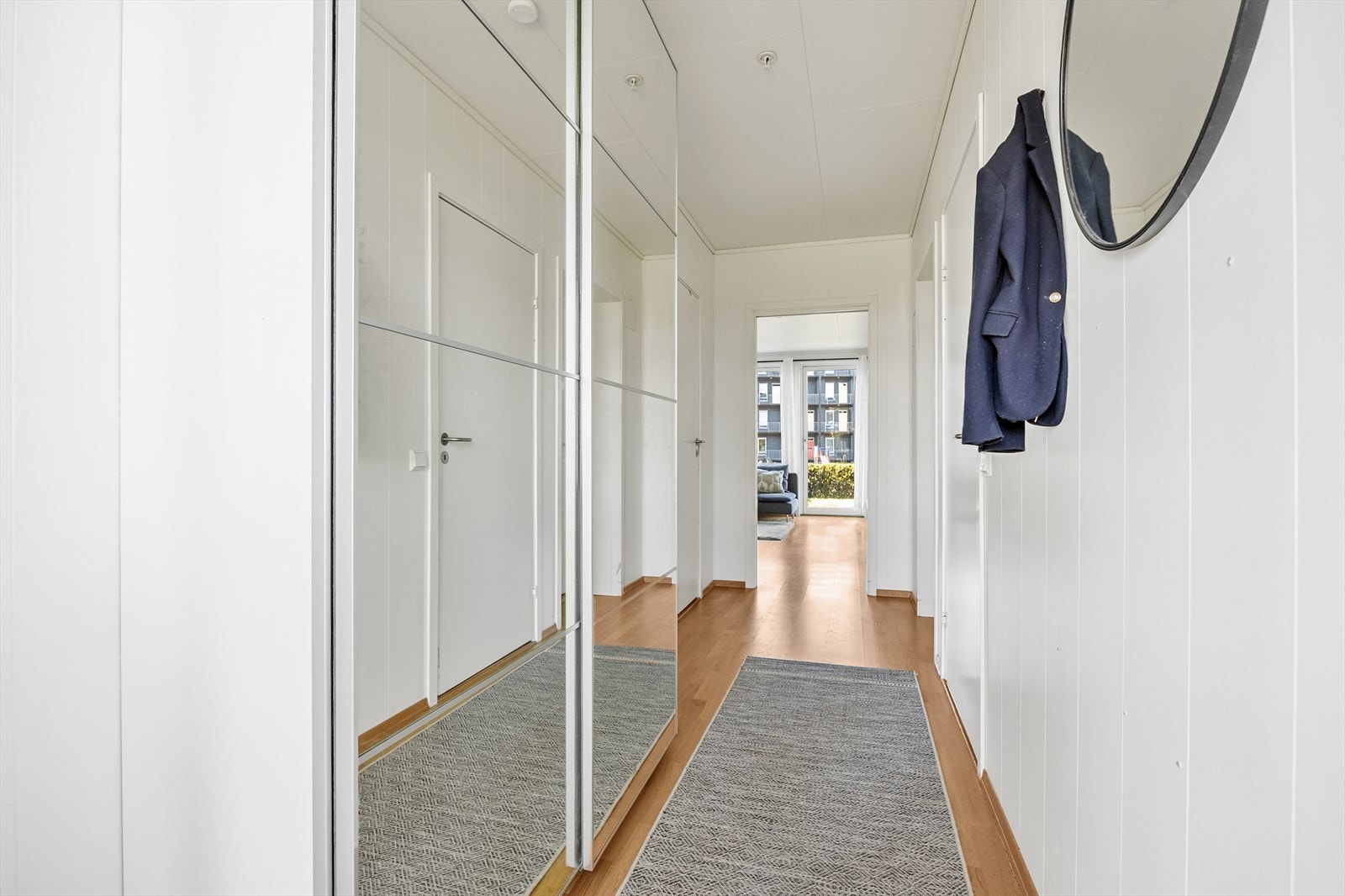 Gangen er godt utnyttet med enda en romslig skyvedørsgarderobe - her med speilfronter. Galleribilde