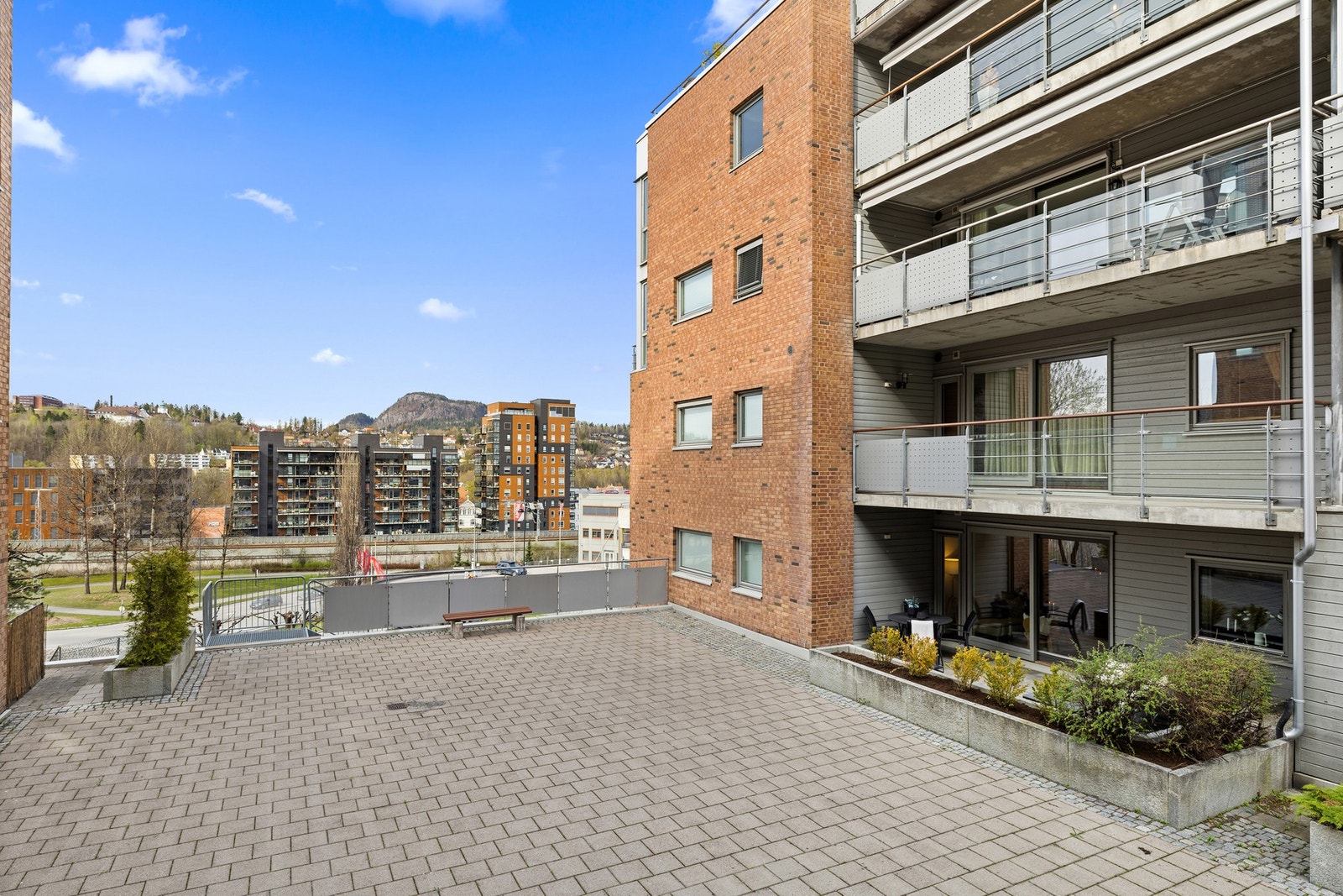 Med leiligheten følger en vestvendt terrasse på bakkeplan, med skyvedørsadkomst fra stue Galleribilde