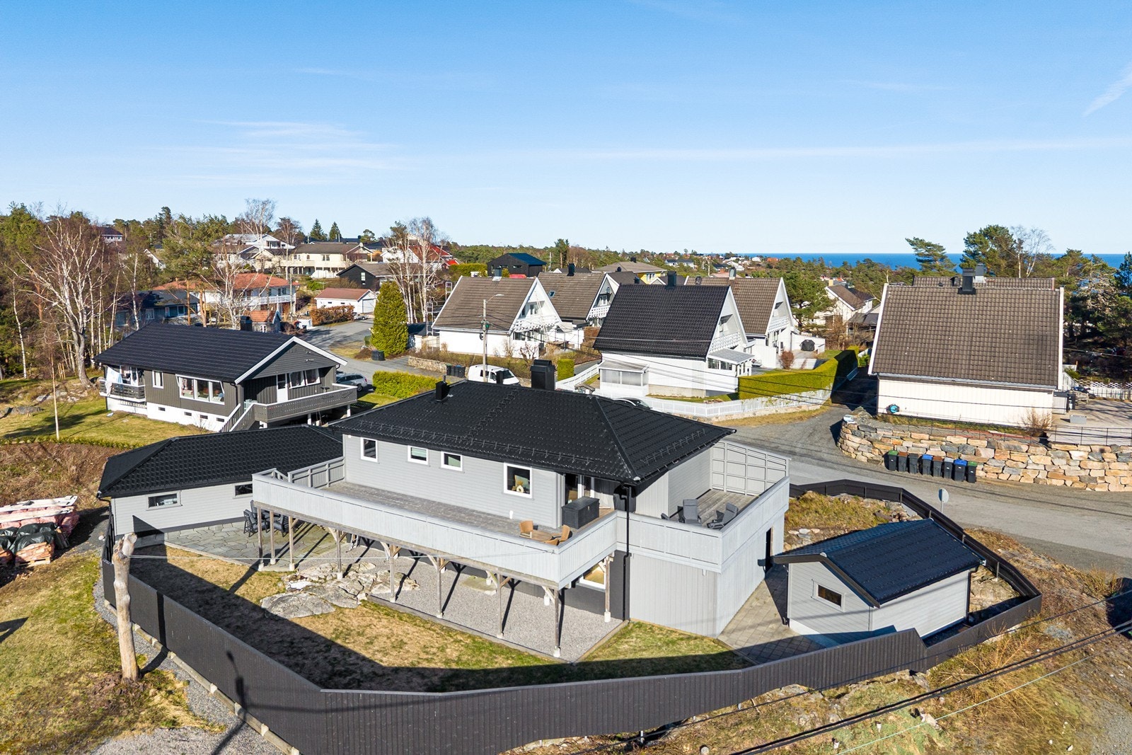 Pent opparbeidet tomt med gjerde, hage, terrasse, bod og garasje Galleribilde