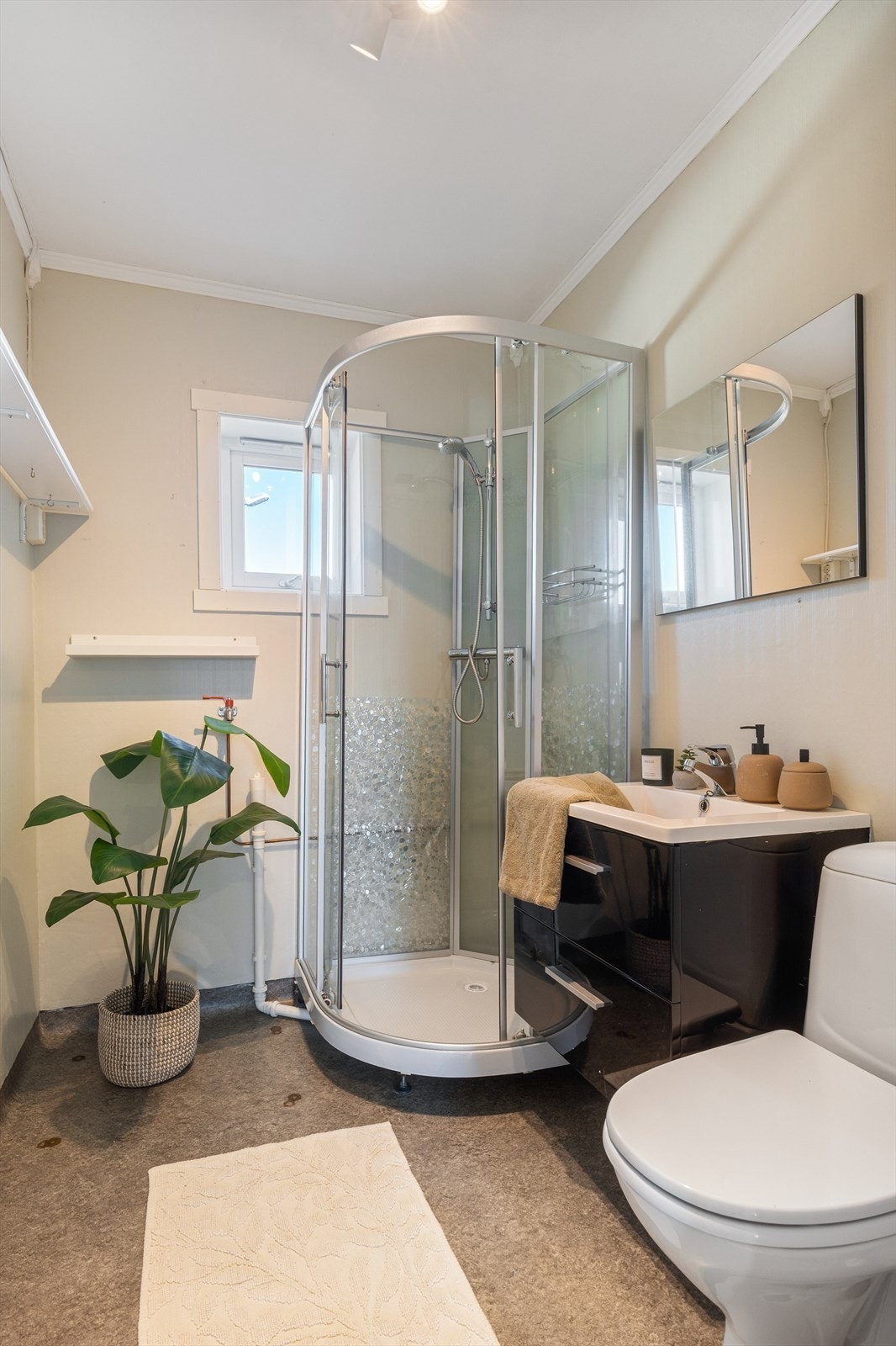 Overflatene på badet består av vinylbelegg på gulvet og våtromstapet på veggene. Galleribilde
