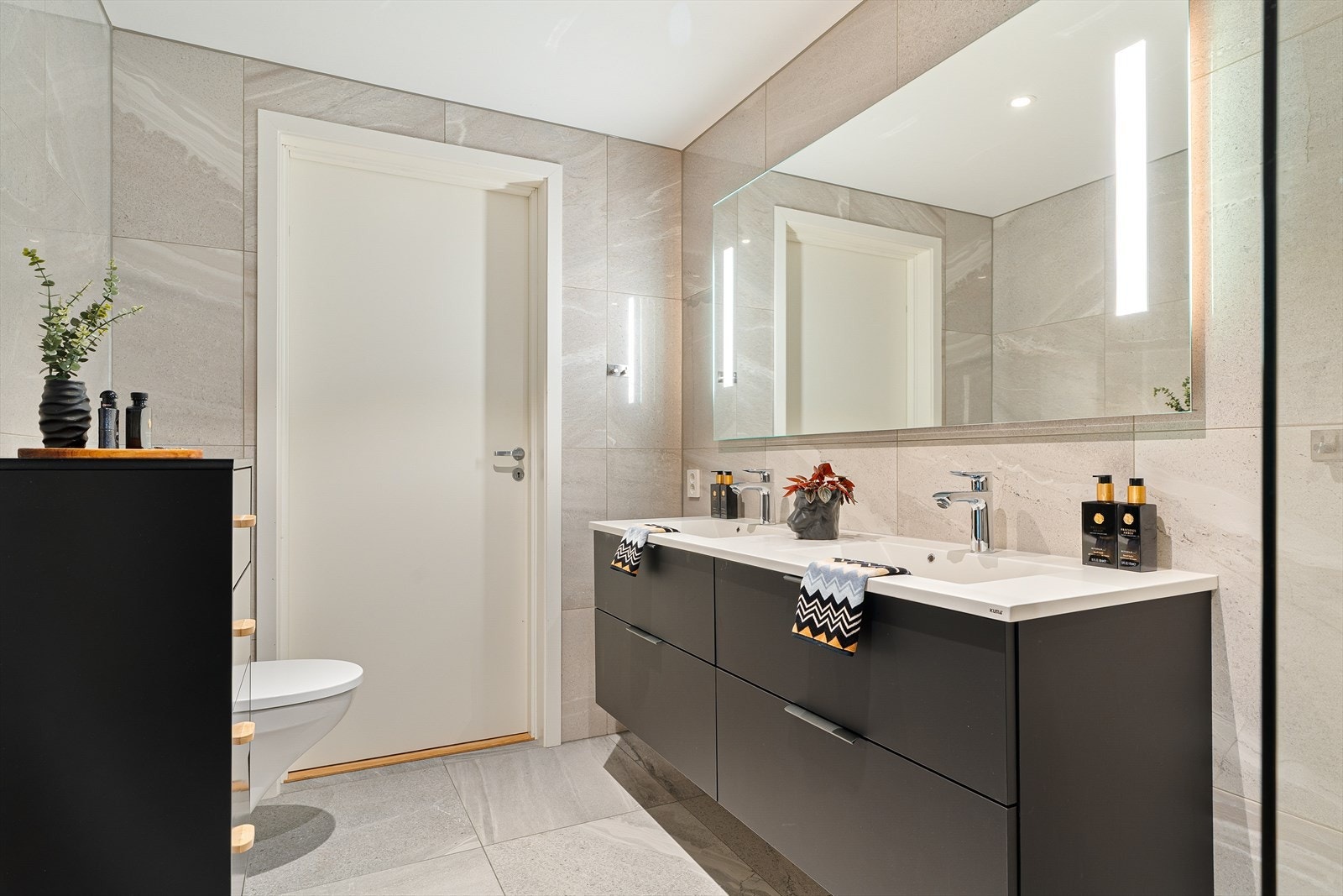 Moderne og stilrent baderom med elegante flislagte overflater og gulvvarme. Galleribilde