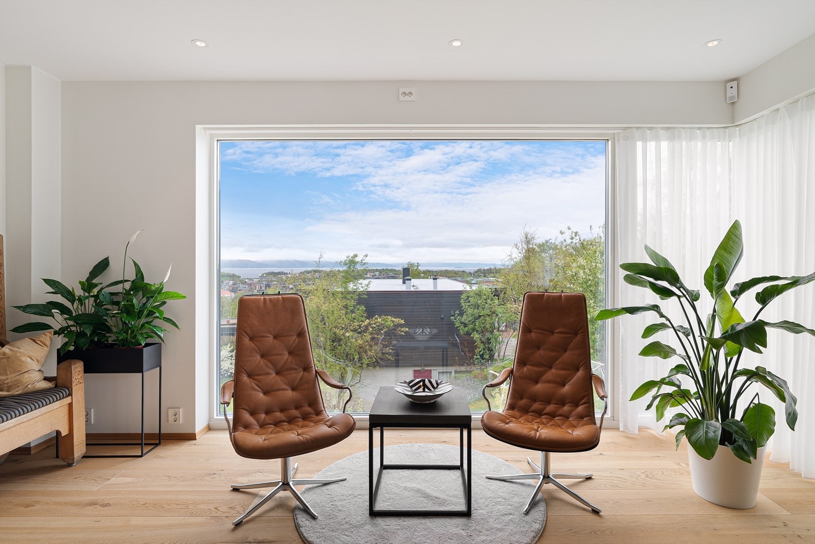 De store vindusflatene rammer inn utsikten på en elegant måte å hvisker ut skille mellom inne og ute. Galleribilde