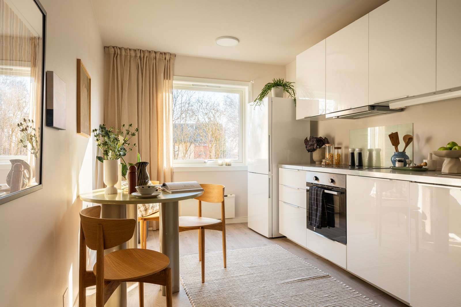 Kjøkkenet ligger i et eget rom i naturlig tilknytning til stuen. God og moderne standard med enstavs laminat på gulv og glatte malte overflater. Galleribilde