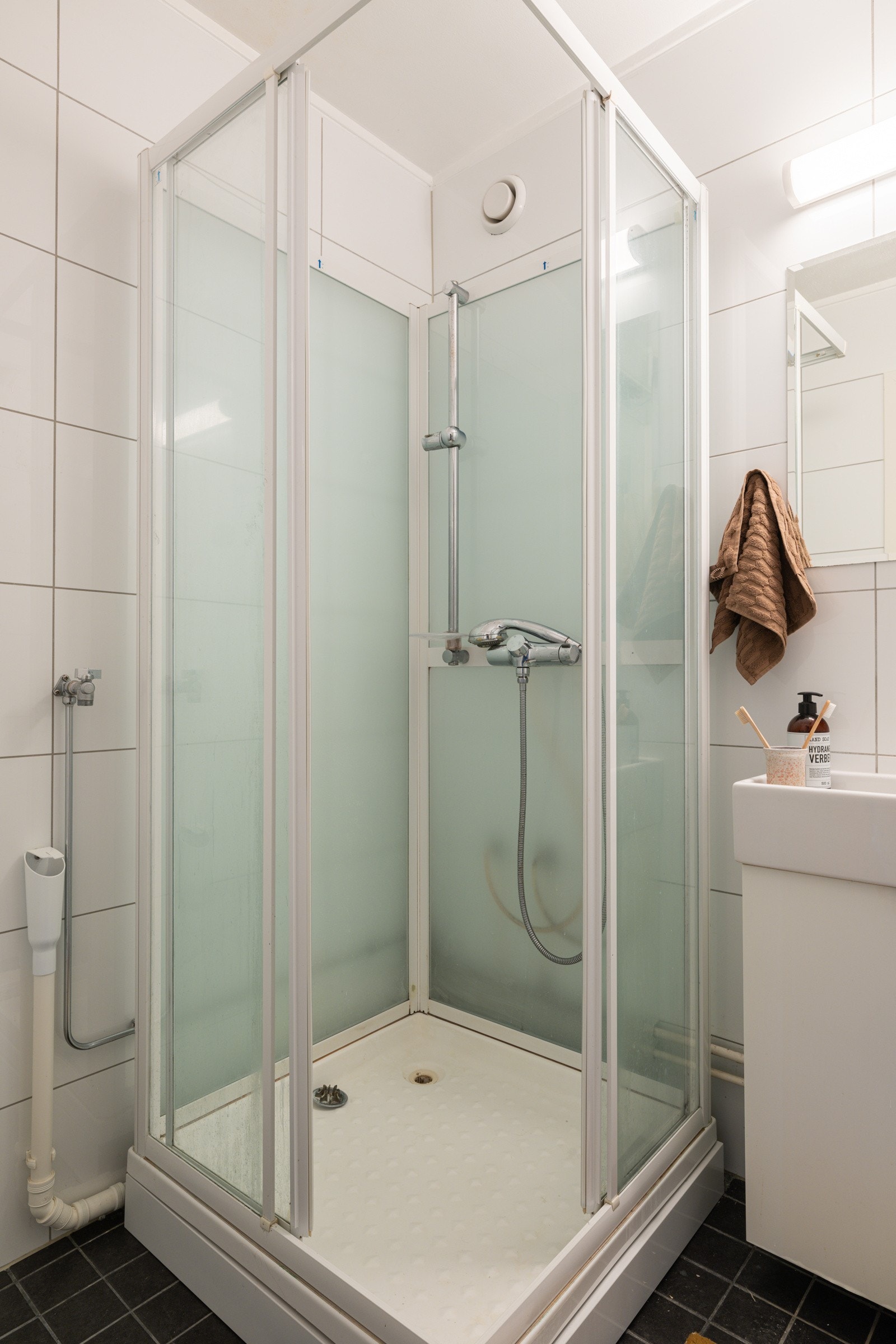 Baderommet er utstyrt med lyst servantskap med speil og belysning over, dusjkabinett og opplegg for vaskemaskin. Galleribilde