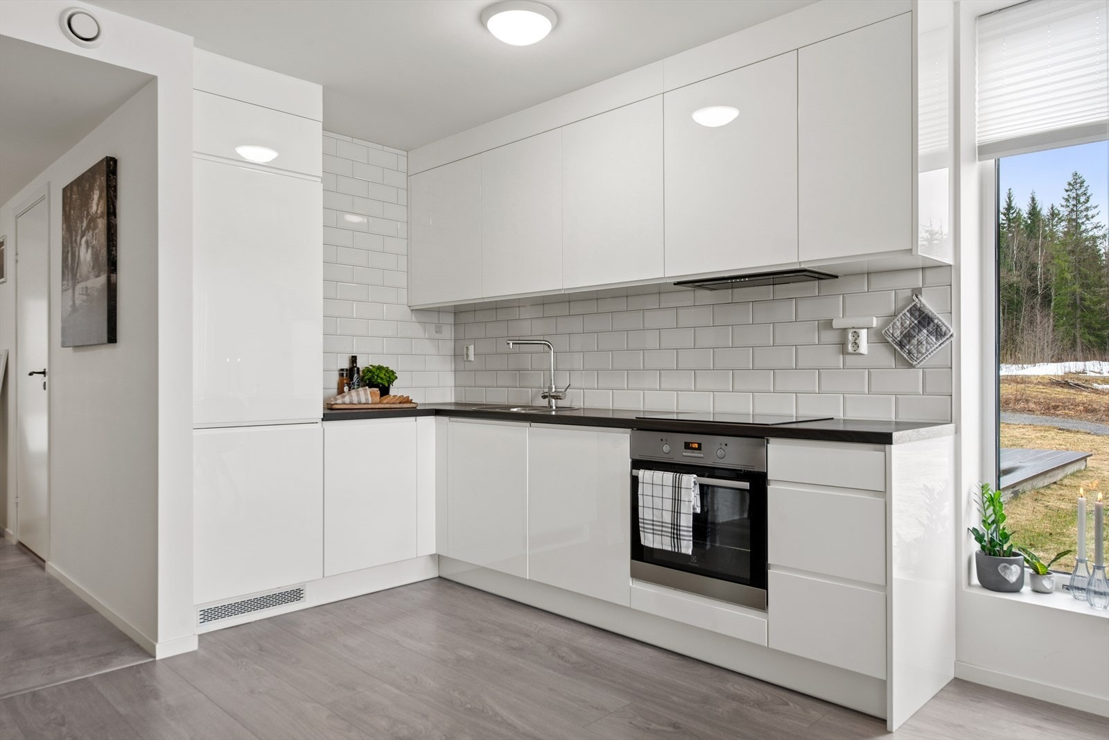 Kjøkkenet har en moderne innredning med glatte fronter og integrert komfyr, koketopp, kjøleskap og oppvaskmaskin. Galleribilde