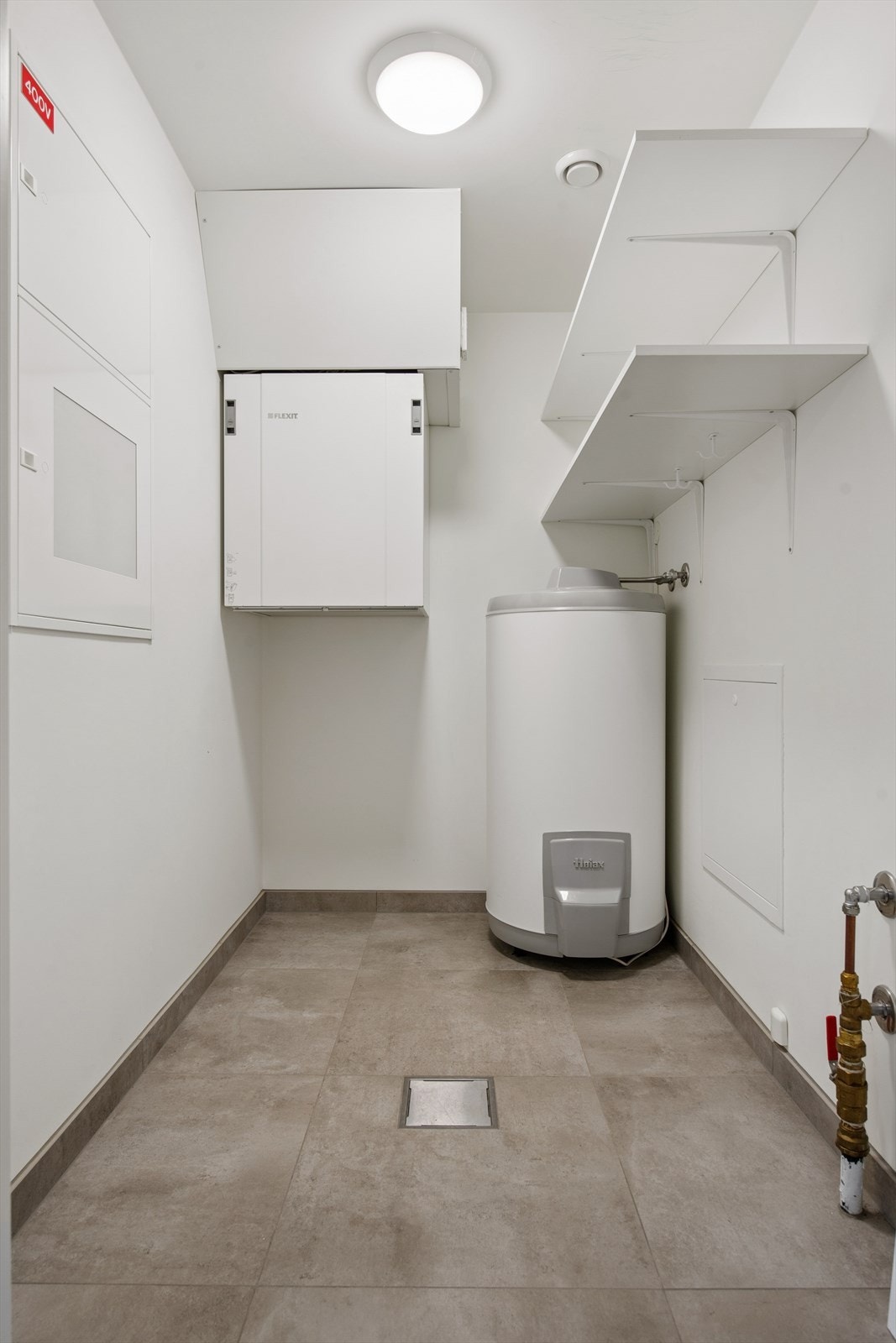 Praktisk teknisk rom/bod med varmtvannsbereder, sikringsskap og aggregat for balansert ventilasjon. Galleribilde