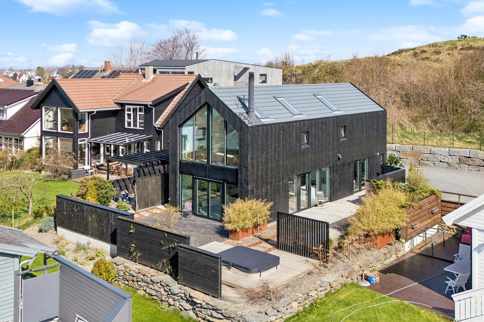 Boligen er omkranset av et velstelt uteområde med flere terrasser og sitteplasser. Galleribilde