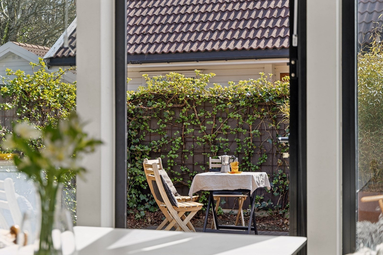 Utsyn til en av de lune uteplassene direkte fra kjøkkenet. Galleribilde