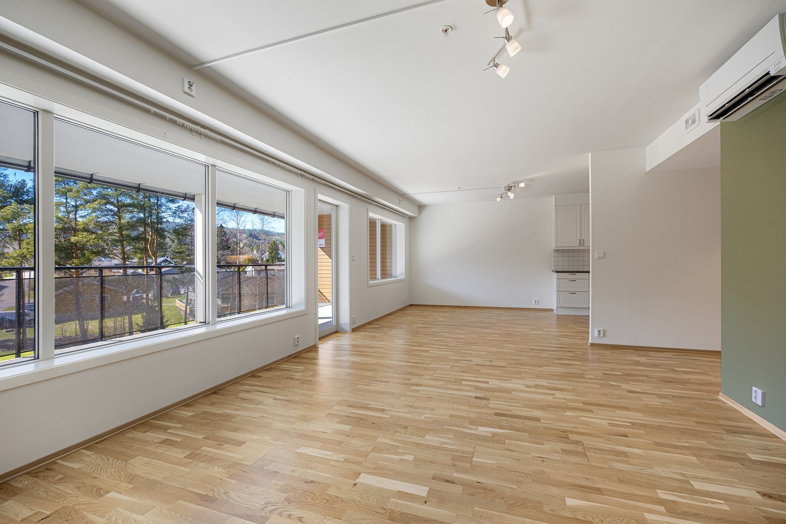 Parketten på gulvet kombineres med veggflater malt i hvitt og olivengrønt. Galleribilde