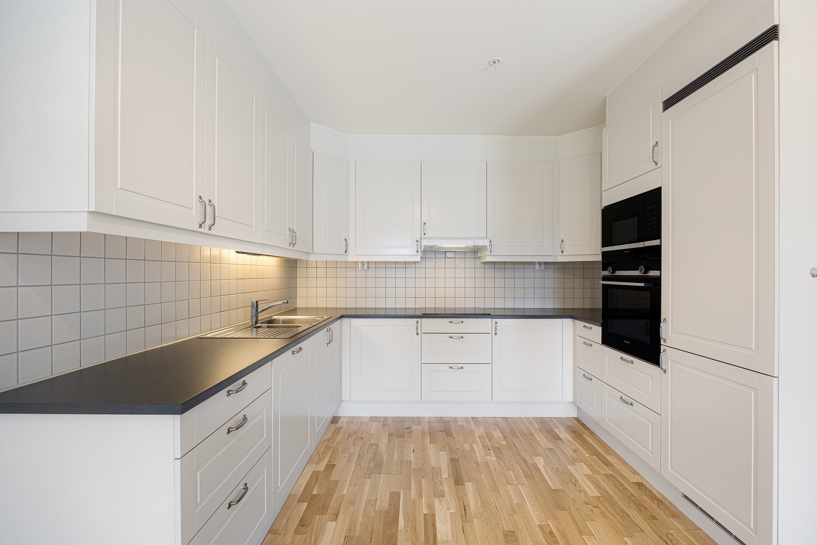 Innredningen er fra Sigdal og har hvite, profilerte fronter og laminatbenkeplate med dobbel oppvaskkum. Galleribilde