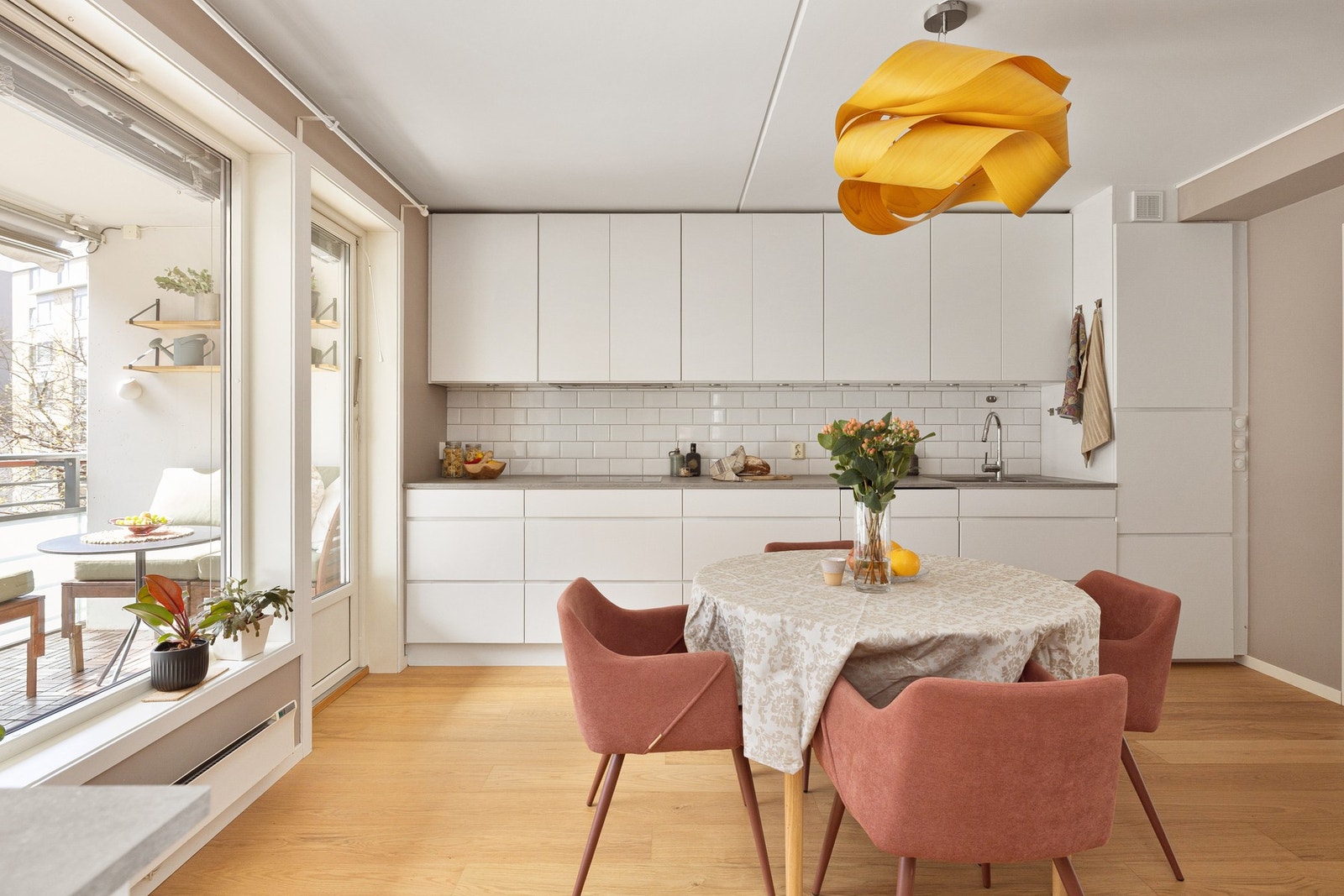 Lys og moderne kjøkkeninnredning fra 2005 med hvite glatte fronter og laminert benkeplate med nedfelt oppvaskkum. Både fint og praktisk med lyse fliser i benkeryggen og belysning under overskapene. Galleribilde