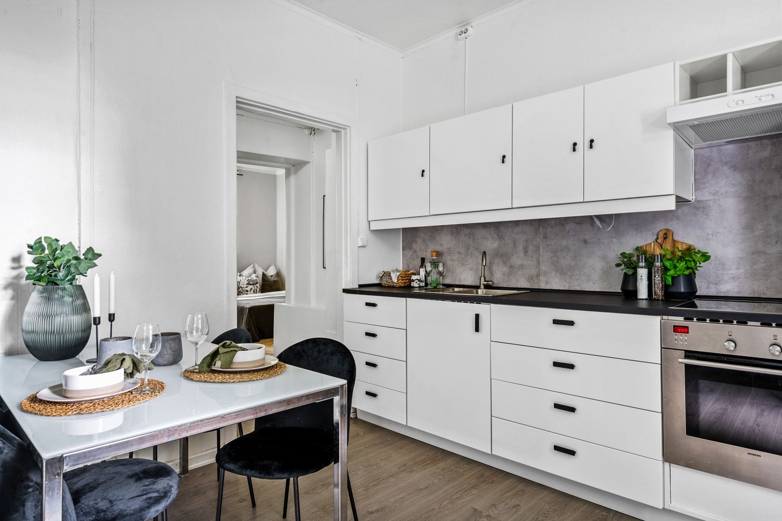 Kjøkkenet er utstyrt med medfølgende hvitevarer som nedfelt platetopp, integrert stekeovn og frittstående kjøleskap med frysedel. Ventilator med kullfilter over platetopp. Galleribilde
