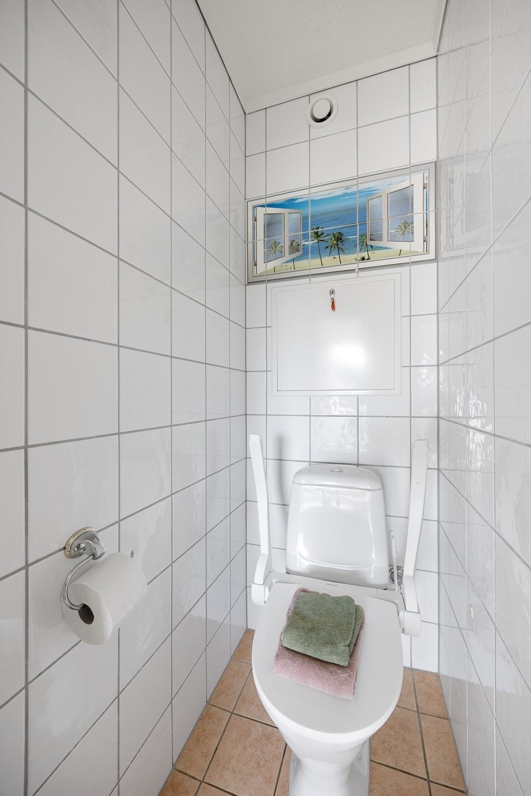 Separat toalettrom med flis på gulv og vegger, malt tak. Galleribilde