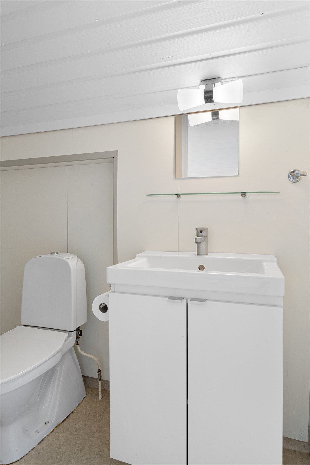 Badet i loftsleiligheten har gulvbelegg, våtromsplater på veggene og vegghengt servantskap. Galleribilde