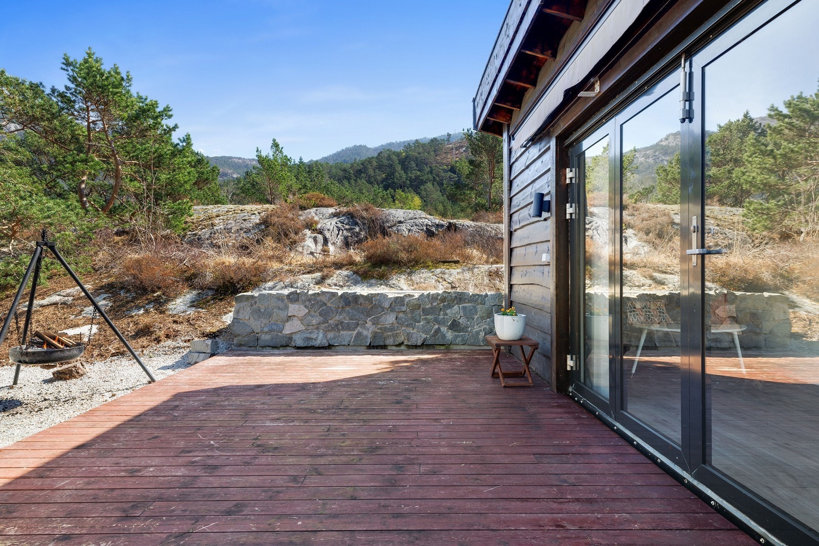 Steingjerde og bålpanne skaper en lun og stemningsfull uteplass. Galleribilde