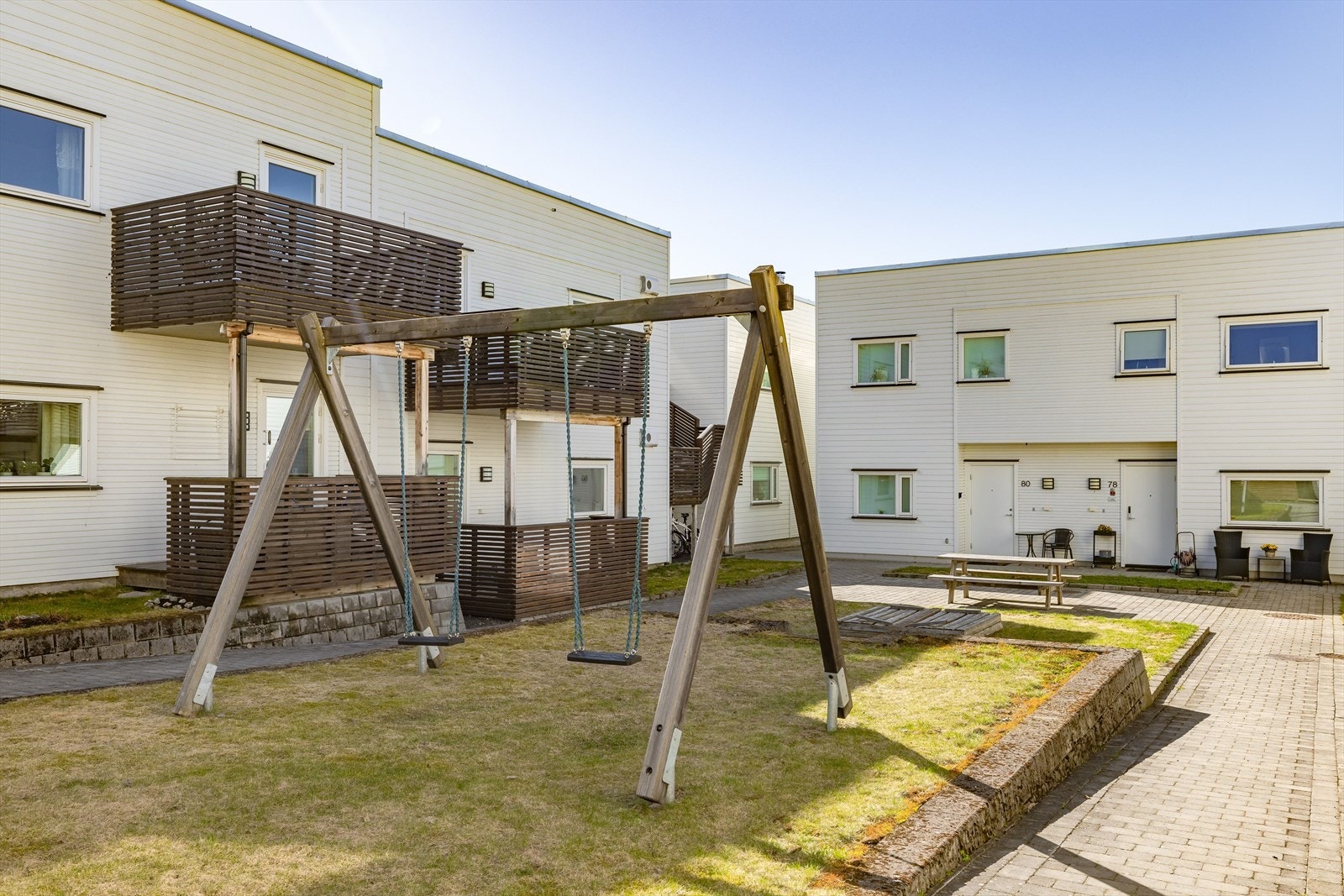 Fine felles uteområder med blant annet benker, bord, huskestativ og sandkasse. Galleribilde