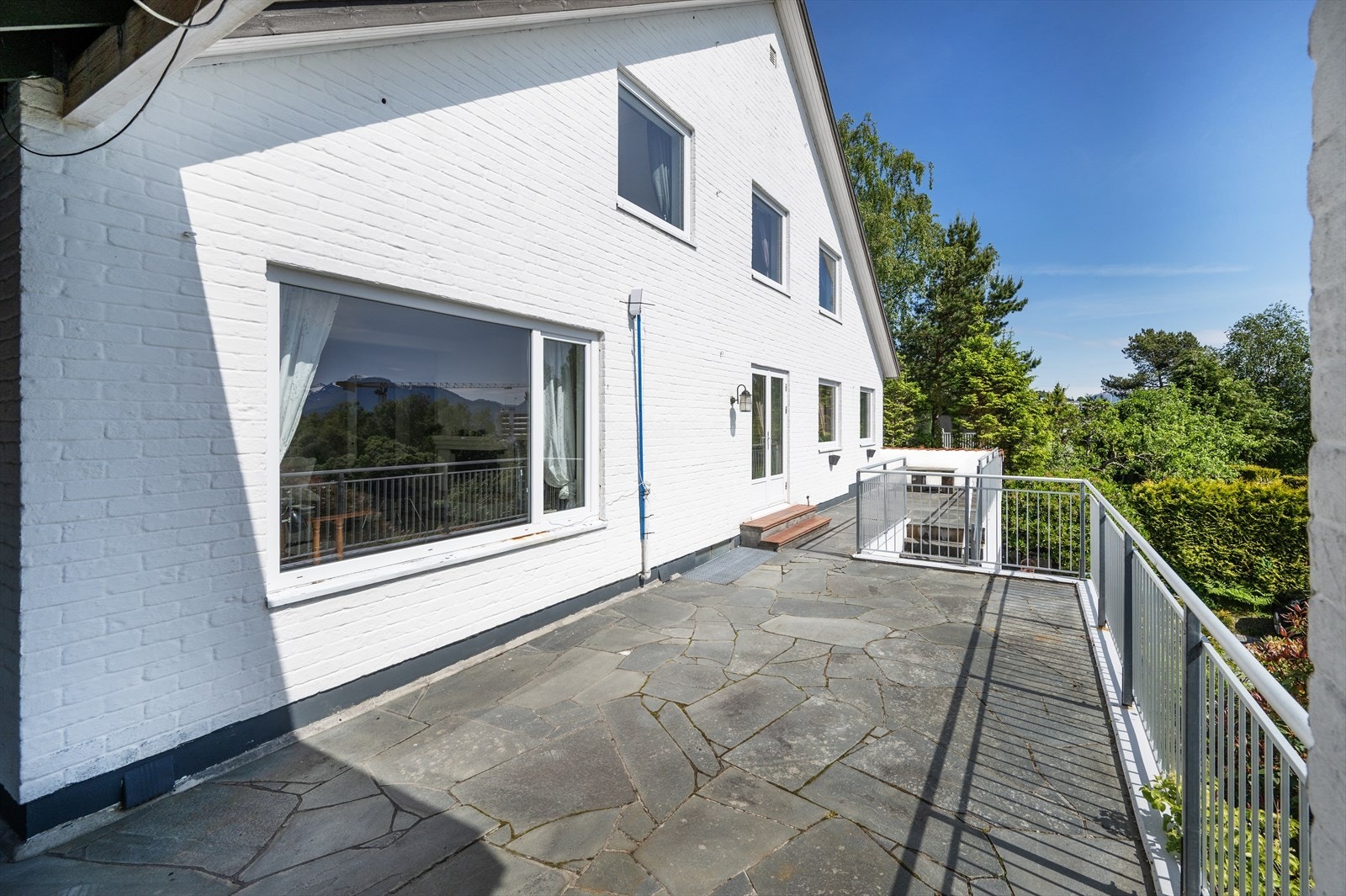 Det er gjort gjennomgående gode og varige materialvalg på eiendommen. Terrassen er belagt med skifer, fasaden er i malt mur og rekkverk er av stål. Galleribilde