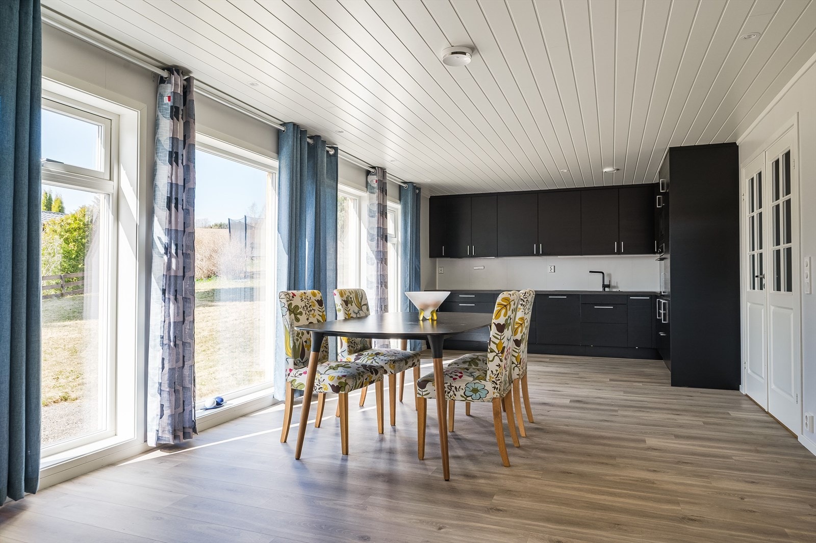Den åpne løsningen mellom stue og kjøkken skaper et stort og sosialt allrom med plass til både spisebord og sofagruppe. Galleribilde