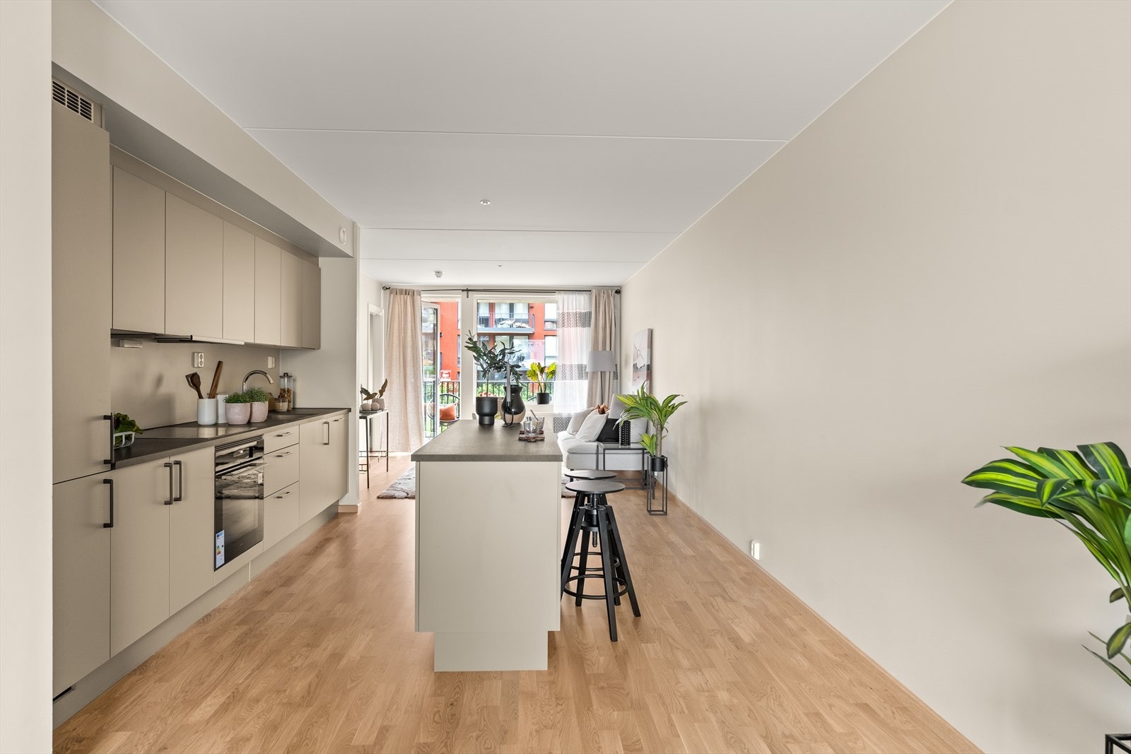 En sosial kjøkkenløsning som kombinerer design og funksjonalitet, med plass til spisebord i tilknytning til stueområdet. Galleribilde