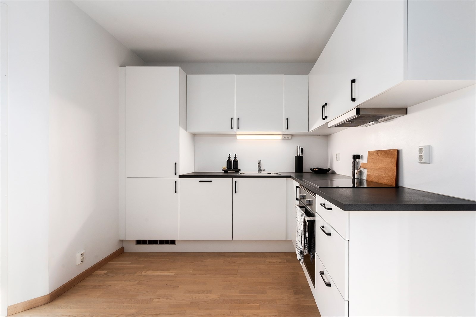 Kjøkkenet har innredning med glatte fronter. Benkeplaten er av laminat med stålkum. Galleribilde