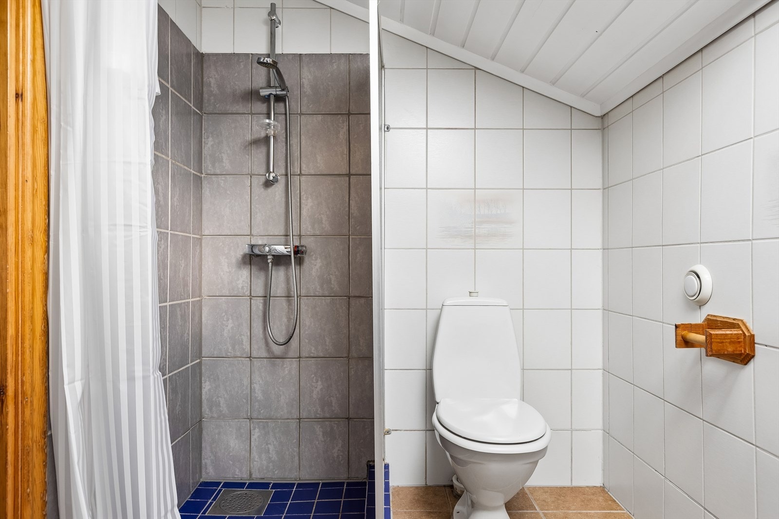 Badet er utstyrt med vegghengt servant, toalett og dusj. Galleribilde