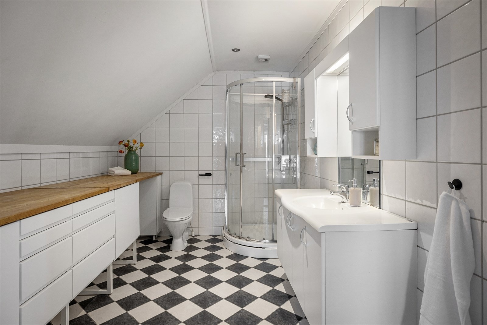 Badet er romslig og praktisk utformet, med plass til både vaskemaskin og oppbevaring. Galleribilde