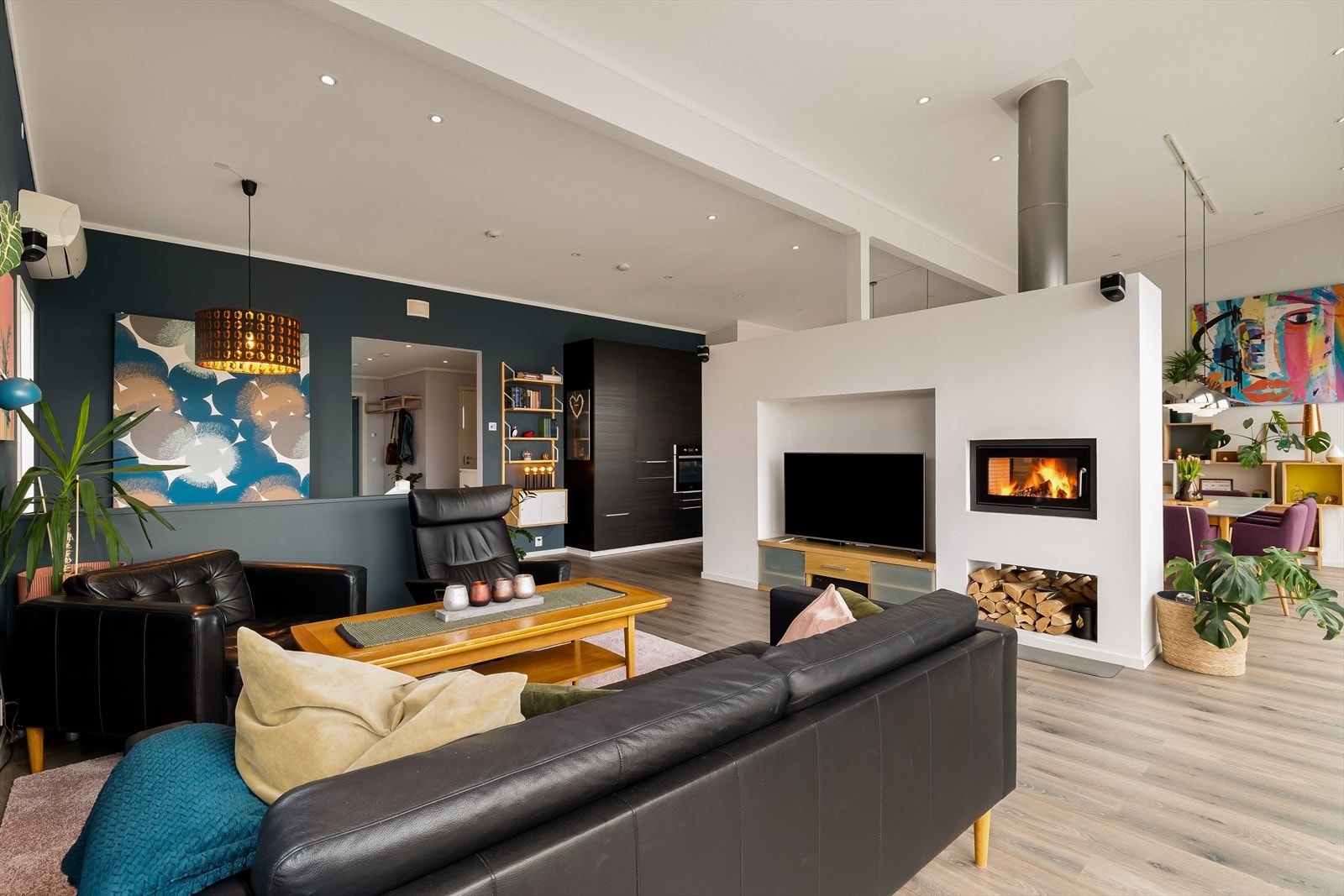 Stuen er et naturlig samlingspunkt i boligen, hvor en elegant peisovn bidrar til både varme og hygge på kjøligere dager. Her kan du nyte rolige kvelder i lune omgivelser, samtidig som rommet inviterer til sosiale sammenkomster med familie og venner. Galleribilde