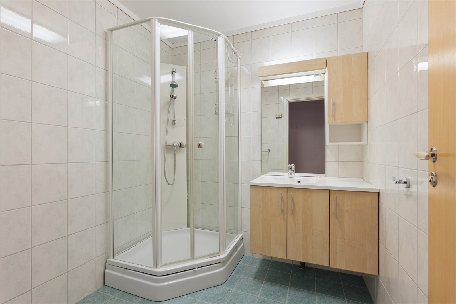 Badet med fliser på veggene og gulvet. Vamekabler i gulv. Galleribilde