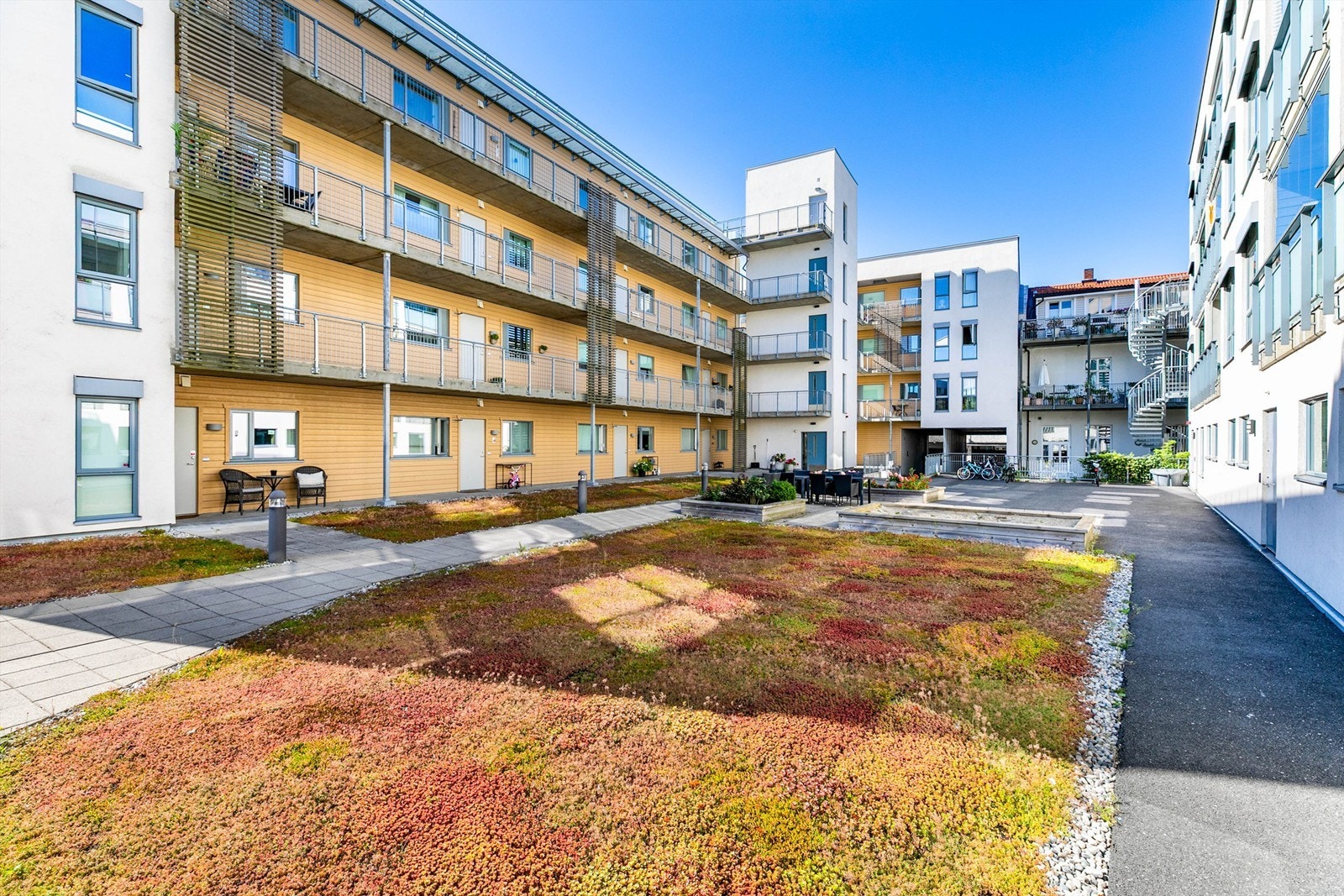 Sameiets skjermede gårdsrom er pent opparbeidet og inkluderer sandkasse samt sittegrupper for beboerne. Galleribilde