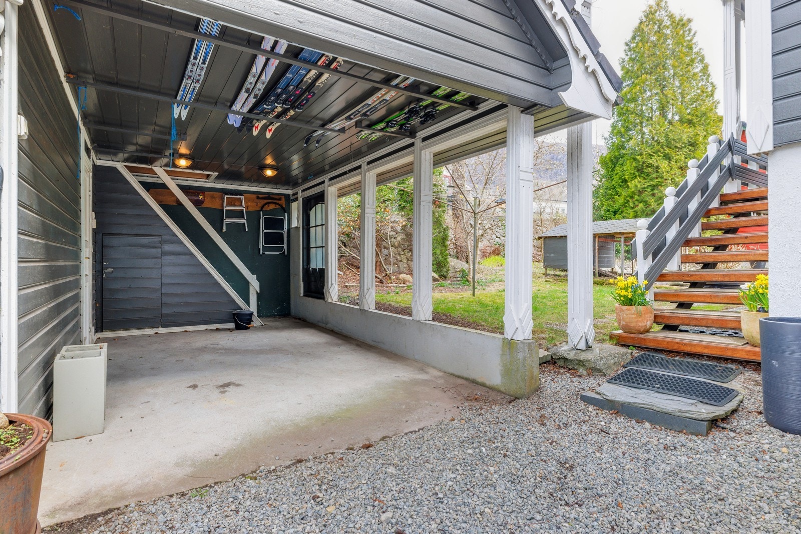 Praktisk carport med oppbevaring av ski, samt trapp opp til rom over garasjen. Galleribilde