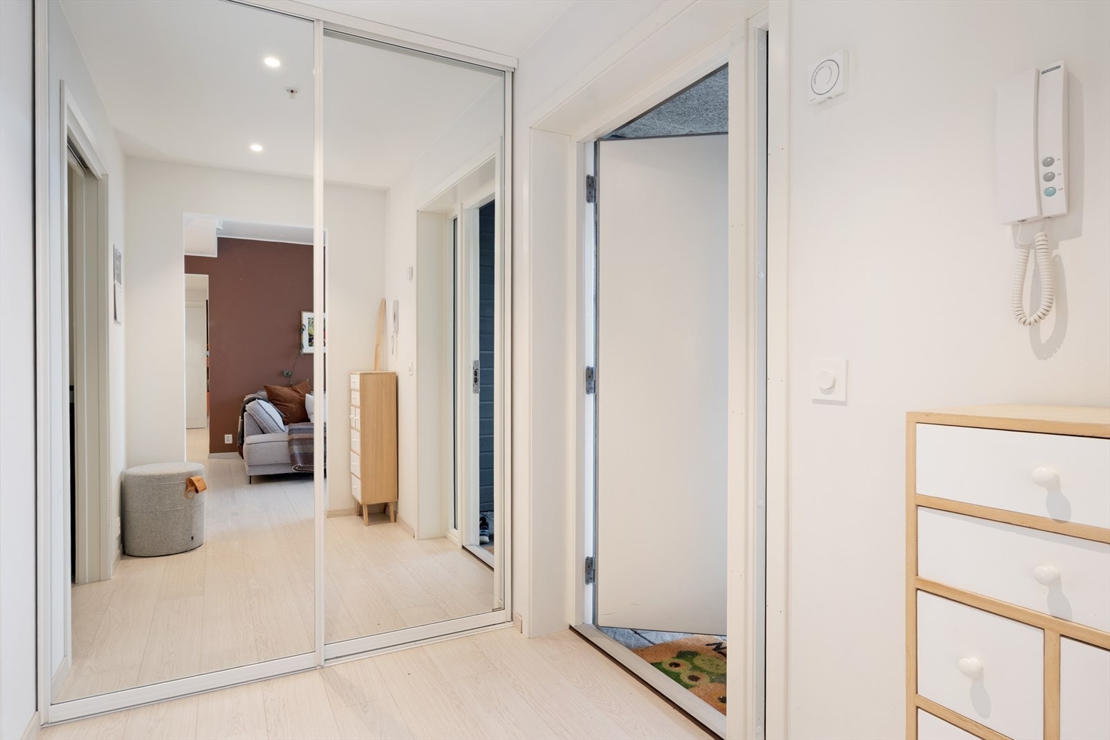 Lys og romsleg entré/gang som er innreia med praktisk skyvedørsgarderobe med spegel i front. Galleribilde