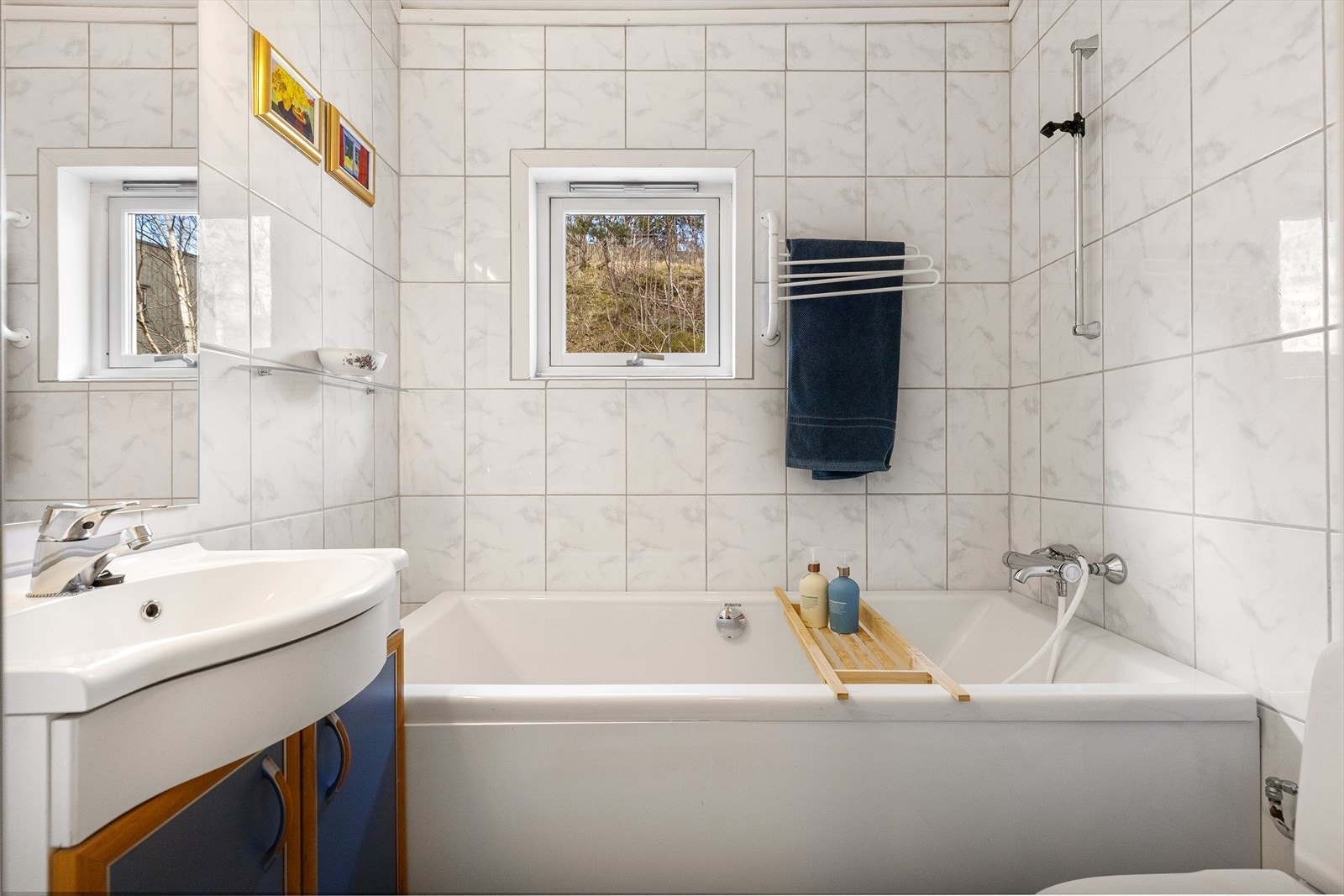 Badet er utstyrt med badekar, klosett og servant med skapinnredning. Galleribilde
