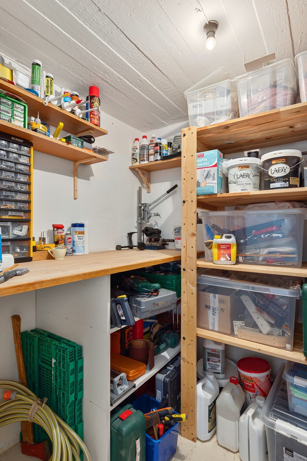 Kjellerbod/verkstedrom med arbeidsbenk og hyller for organisering av verktøy og utstyr. Galleribilde