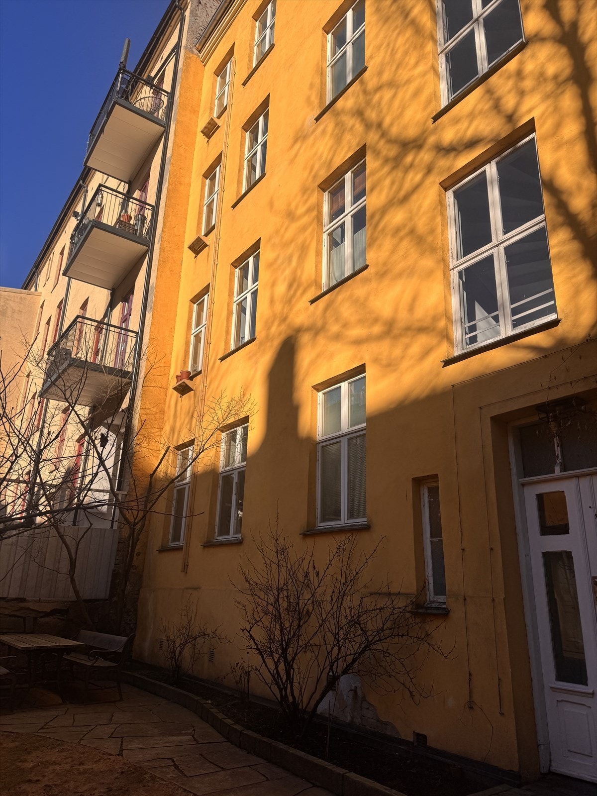 Selgers private bilde av fasade fra bakgård. Bildet er tatt i slutten av mars 2026 for å illustrere at man får godt med naturlig lys inn i leiligheten. Galleribilde