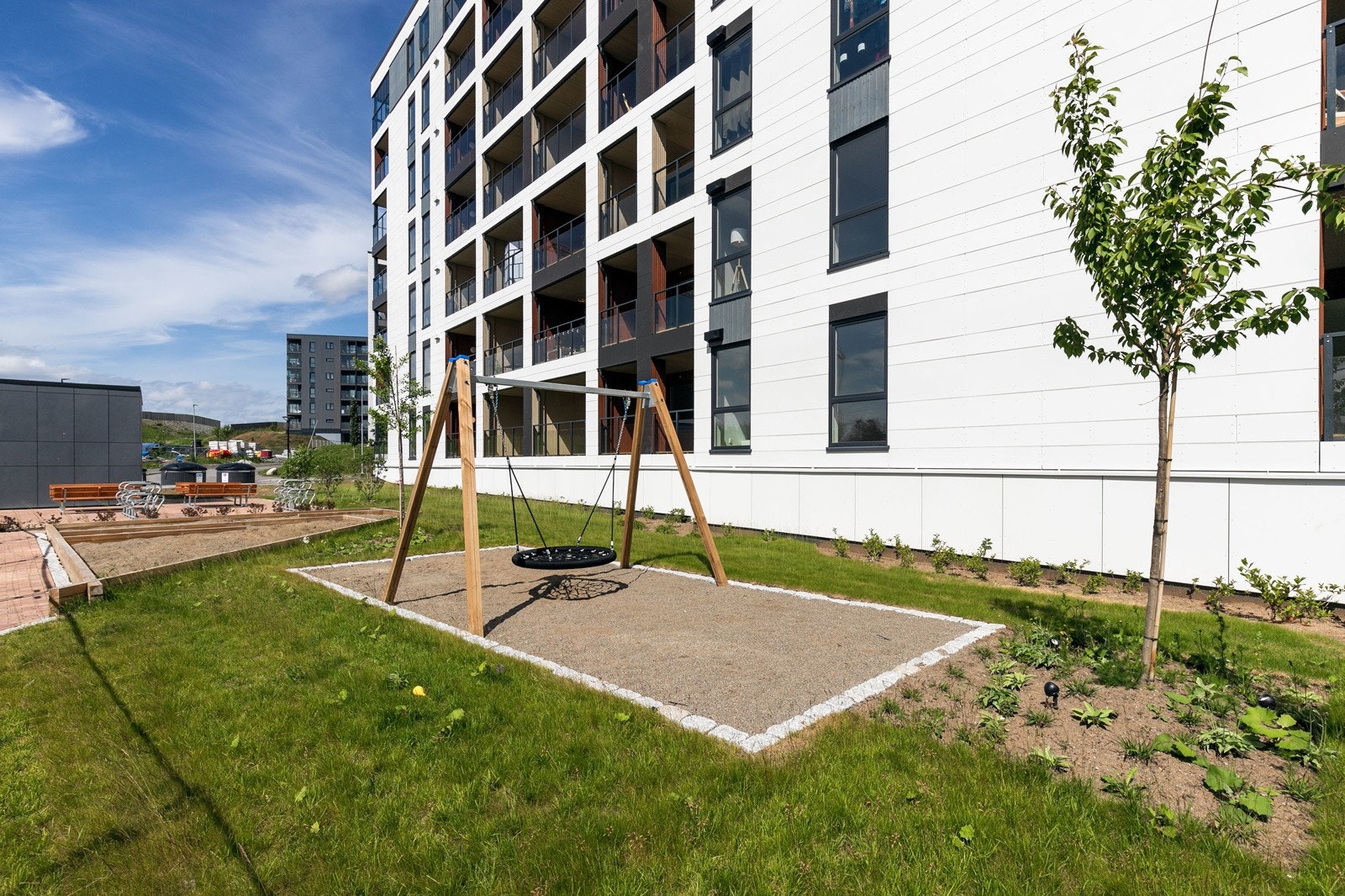 Fellesarealer med utendørs sitteplasser, sykkelparkering og lekeplass Galleribilde