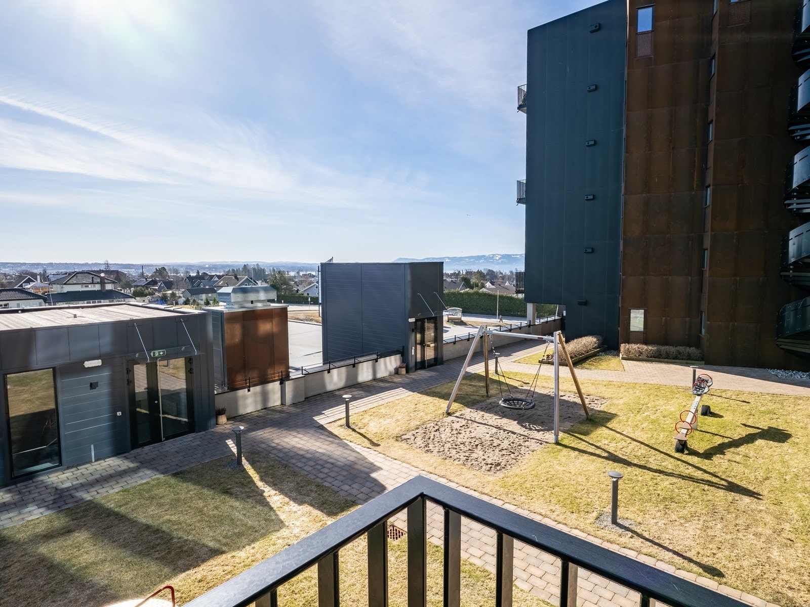 Leiligheten har to balkonger. Her fra soverommets private uteplass, med utsikt over sameiets fellesområde. Galleribilde