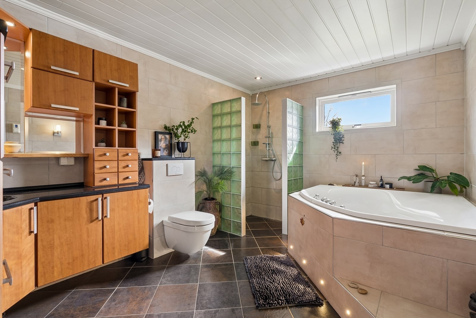 Badet har en dusjnisje med glassbyggerstein og har rikelig med skap- og skuffeplass. Galleribilde