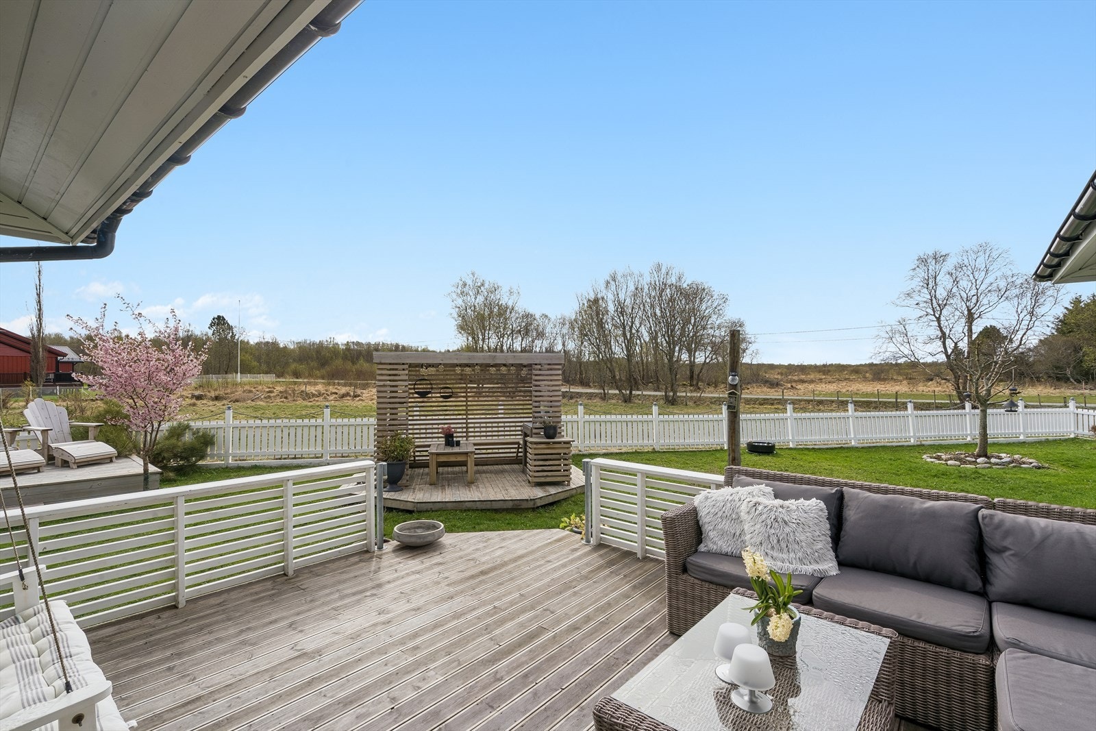 Romslig terrasse med liggende rekkverkog nedgag til hagen. Galleribilde