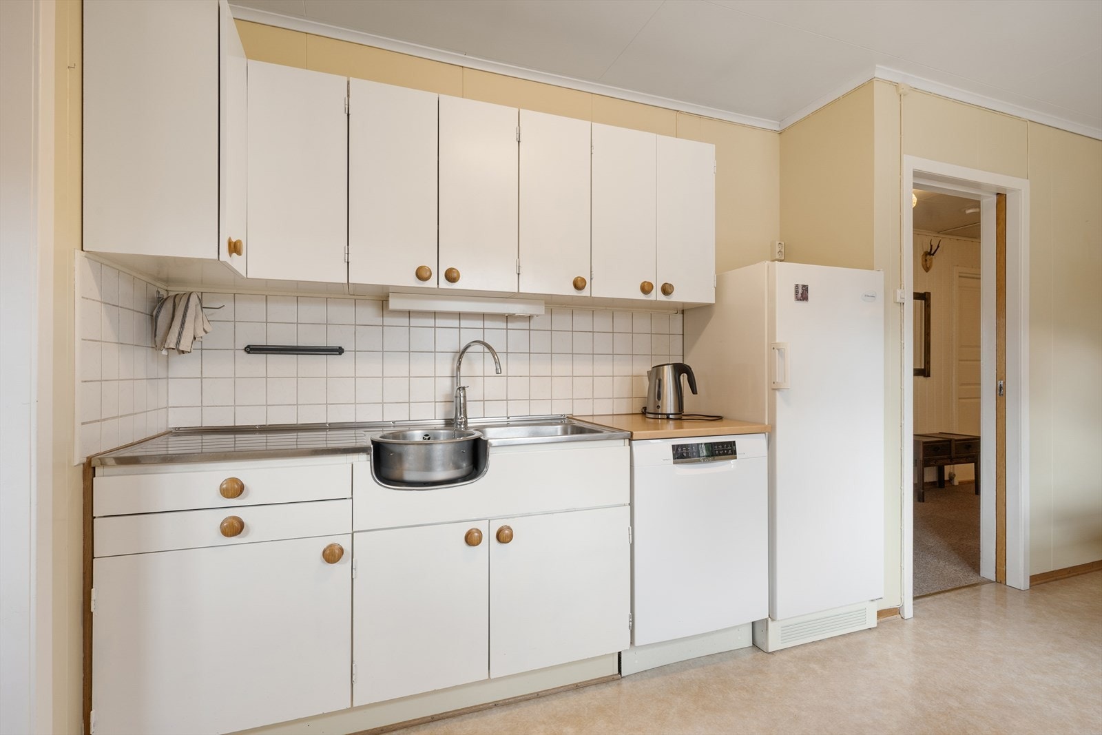 Kjøkkeninnredning med glatte fronter, laminat benkeplate og ventilator med avtrekk ut. Galleribilde