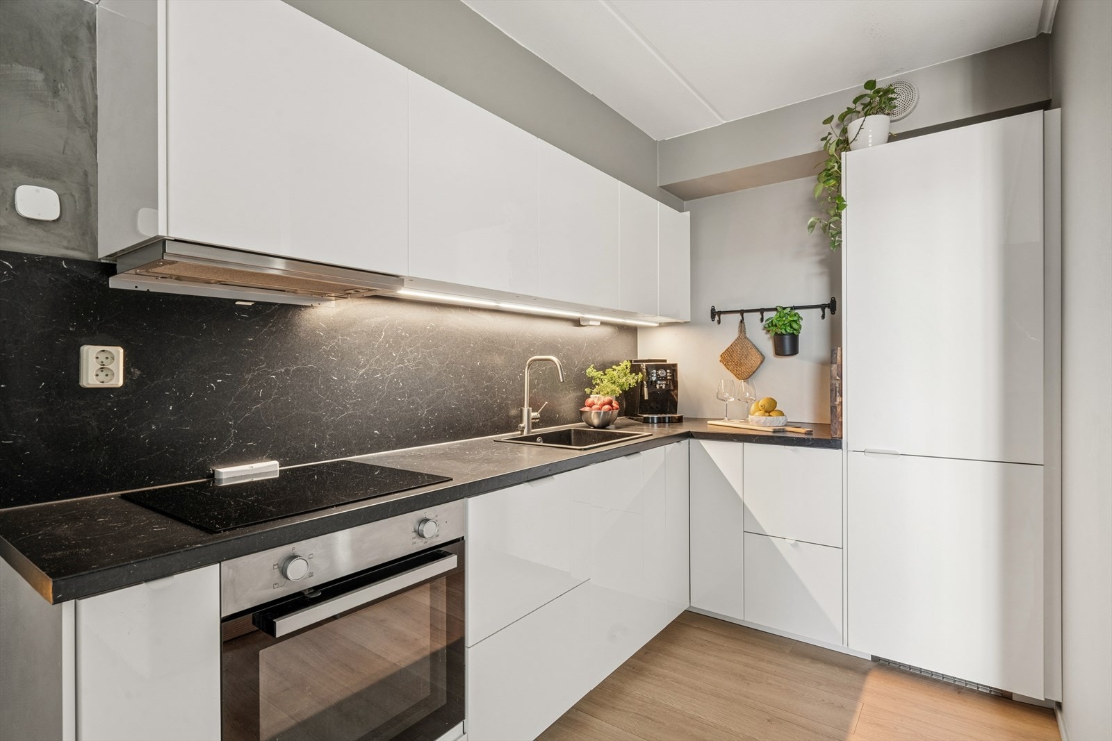 Kjøkkenet fremstår moderne og stilrent, med innredning fra IKEA med glatte fronter og laminat benkeplate. Det er utstyrt med kjøl/fryseskap, oppvaskmaskin, platetopp og stekeovn. Galleribilde
