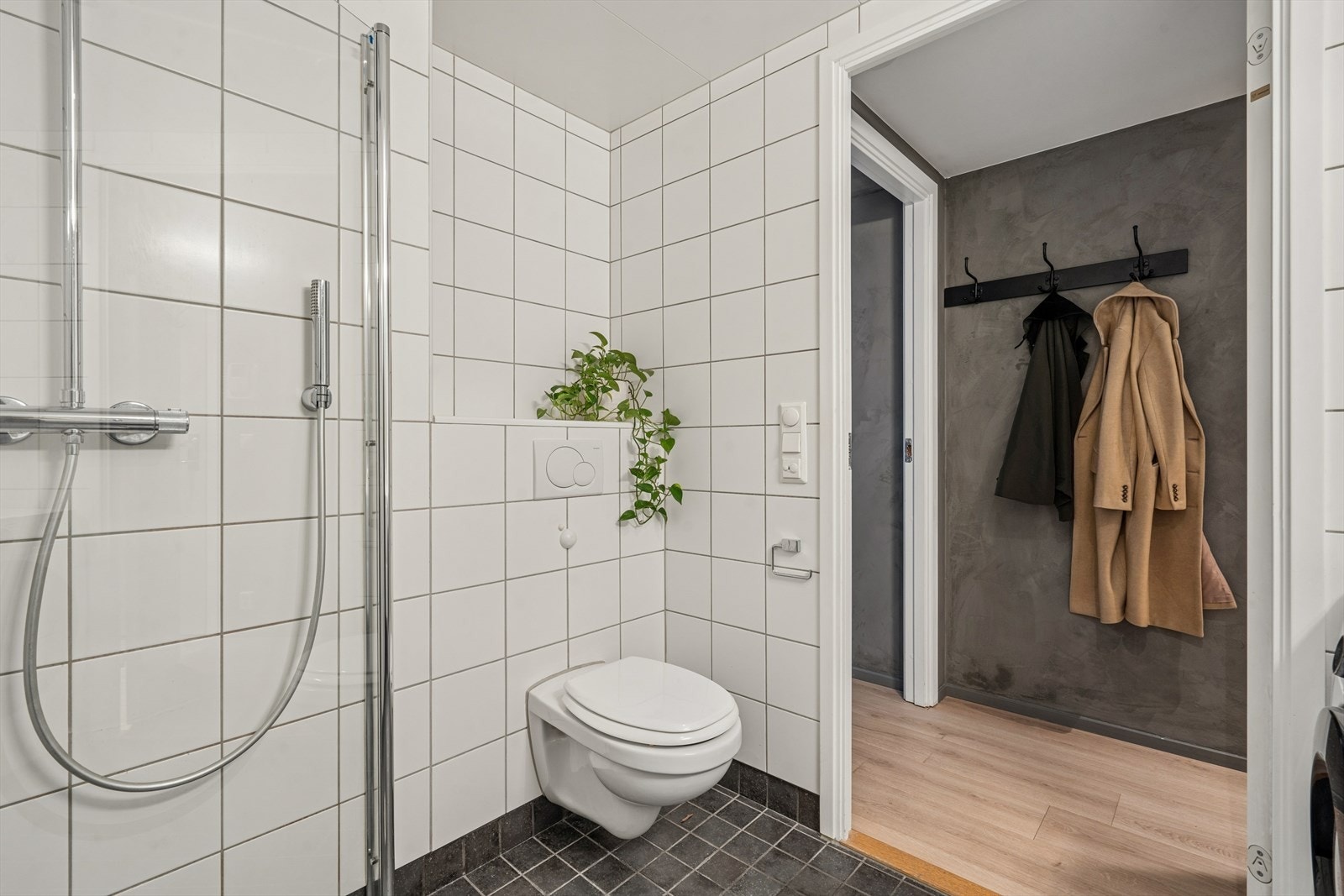 Badet er utstyrt med nedfelt servant, veggmontert toalett, speil med belysning, dusjvegger/hjørne og opplegg for vaskemaskin. Avtrekk via balansert ventilasjon. Galleribilde