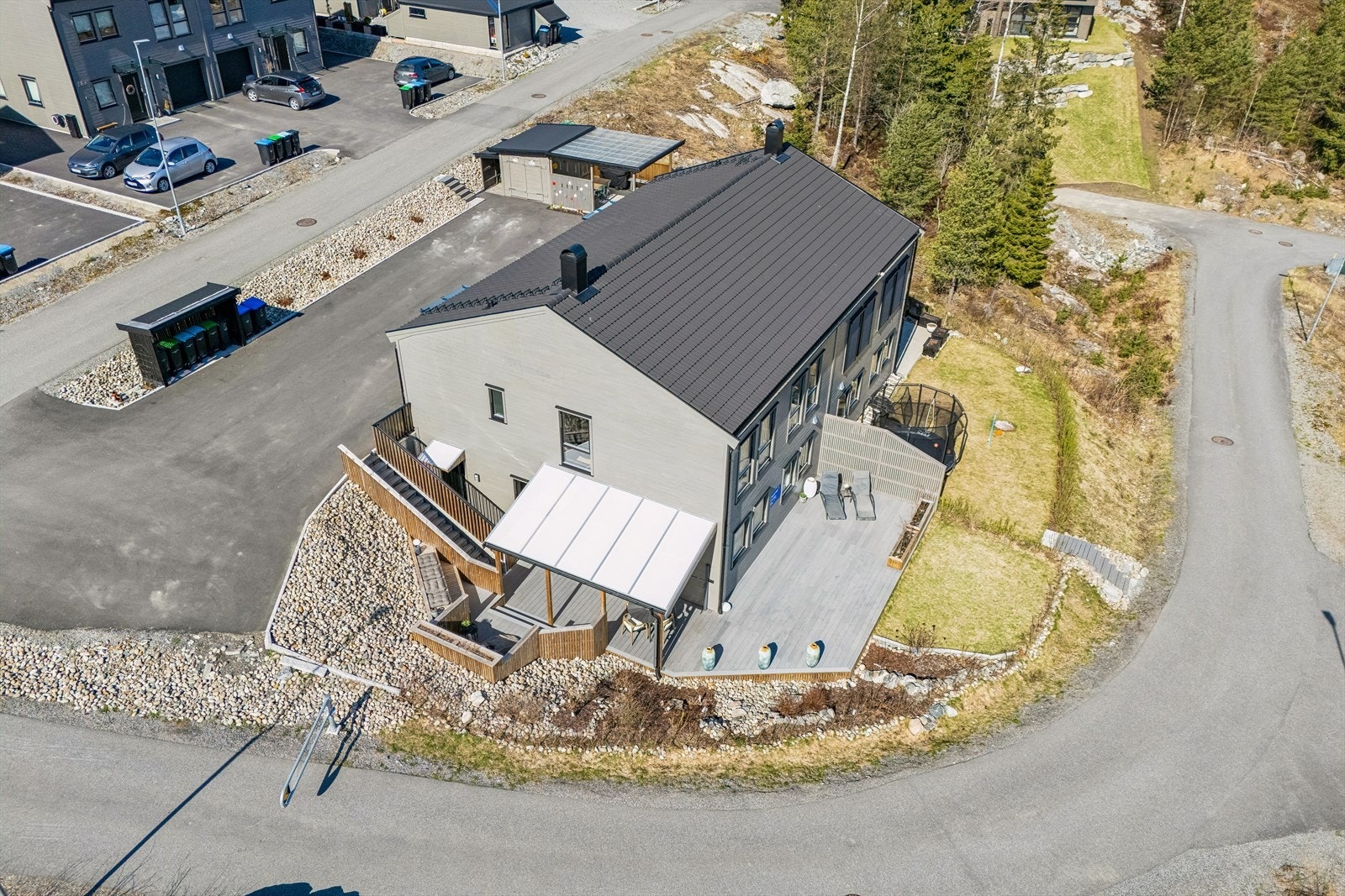 Oversikt over eiendommen og den store terrassen som omkranser boligen. Galleribilde