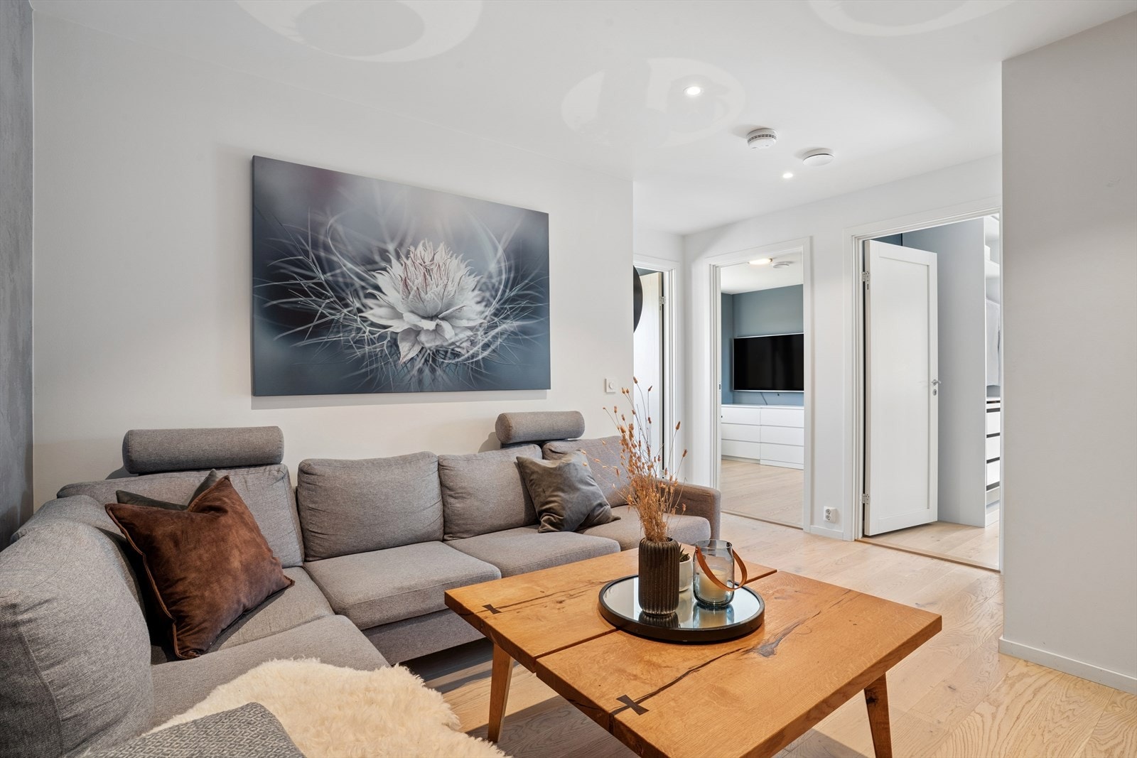 Downlights i taket sørger for en jevn og behagelig belysning, og det gjennomgående parkettgulvet binder sonene sammen på en harmonisk måte. Galleribilde