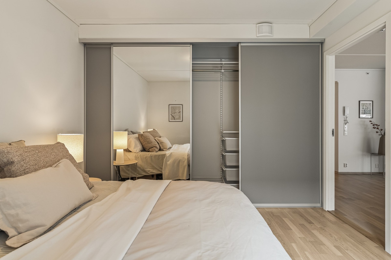 En romslig skyvedørsgarderobe med speilfronter gir rikelig med oppbevaringsplass. Galleribilde