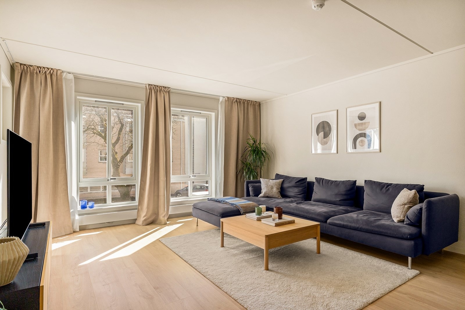 Stuen er en del av den åpne løsningen mot kjøkkenet, og har plass til en romslig sofagruppe. Vinduene er toppsvingvinduer med 2-lags glass. Galleribilde