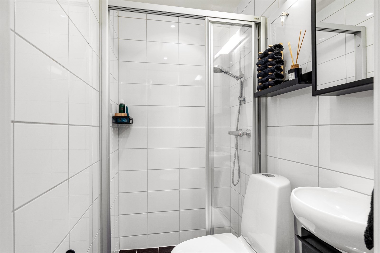 Badet er innredet med WC, dusjplass med vegger og servant med ettgreps blandebatteri i innredning. Galleribilde
