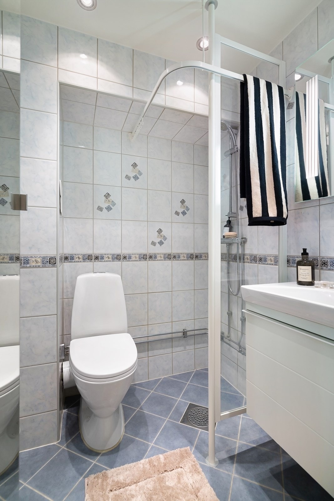 Badet er flislagt og utstyrt med servantinnredning, gulvstående toalett og dusj på gulv. Avtrekk er mekanisk. Galleribilde